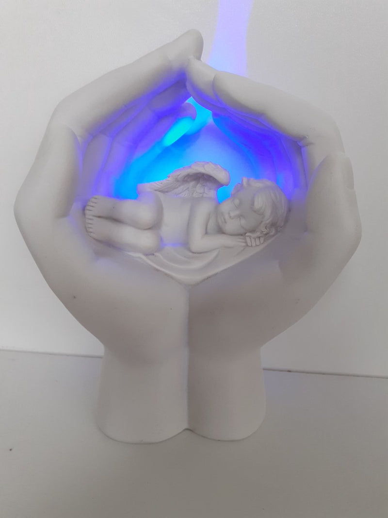 Schlafender Cherub in Händen mit LED